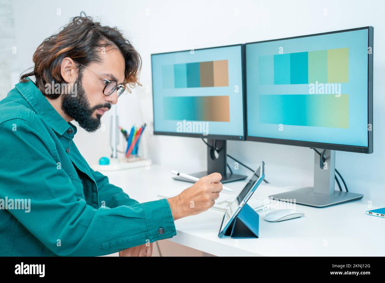 Graphiste travaillant avec un ordinateur tablette numérique stylet smartphone dans un bureau moderne. Banque D'Images