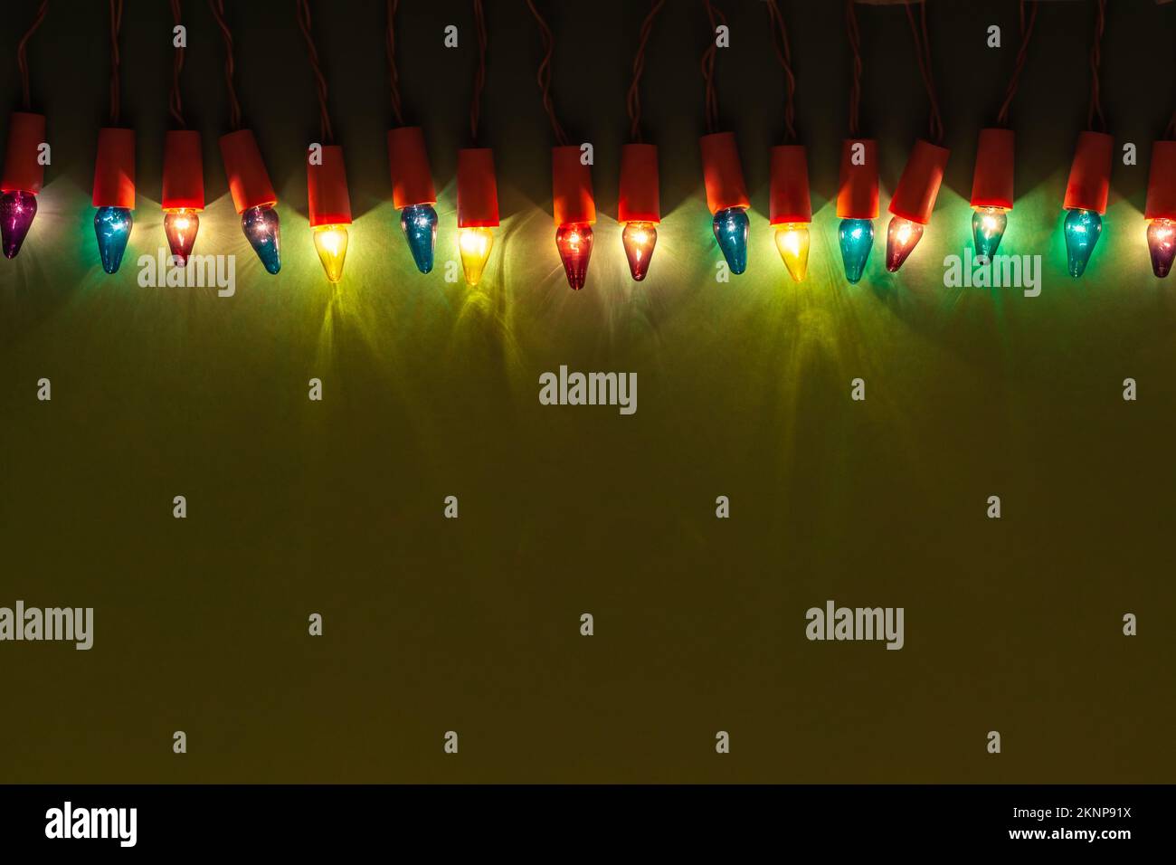 Lumières de Noël de différentes couleurs sur fond vert Banque D'Images