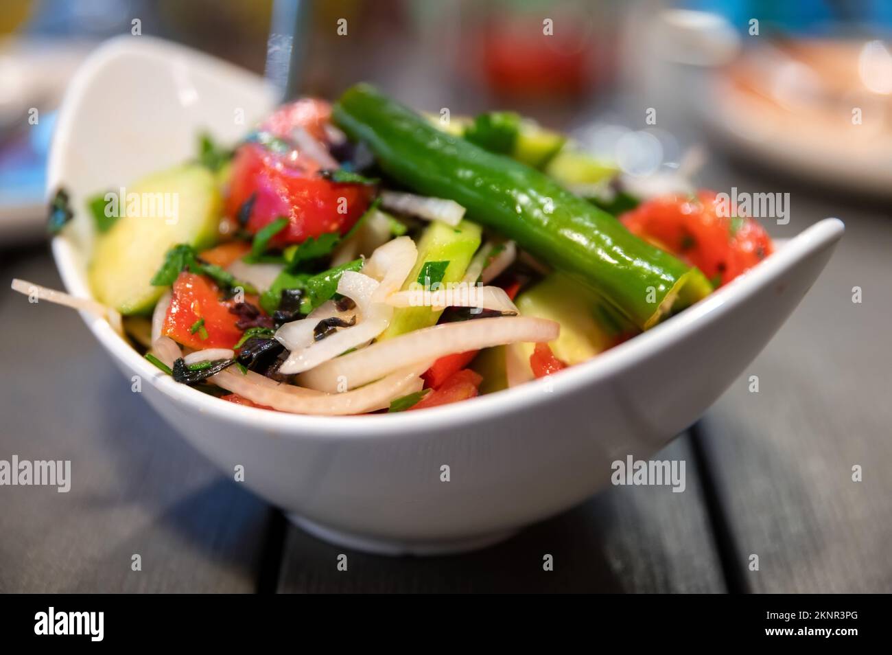 Salade fraîche aux épinards, oignons et tomates avec concombres sur fond rustique. Gros plan et mise au point sélective. Concept d'alimentation saine Banque D'Images
