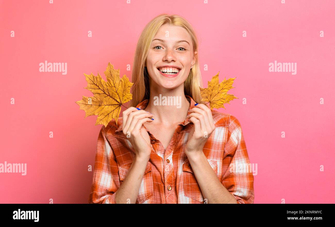 Feuille d'érable dorée automne fille. Femme souriante dans des vêtements décontractés avec des feuilles jaunes. Banque D'Images