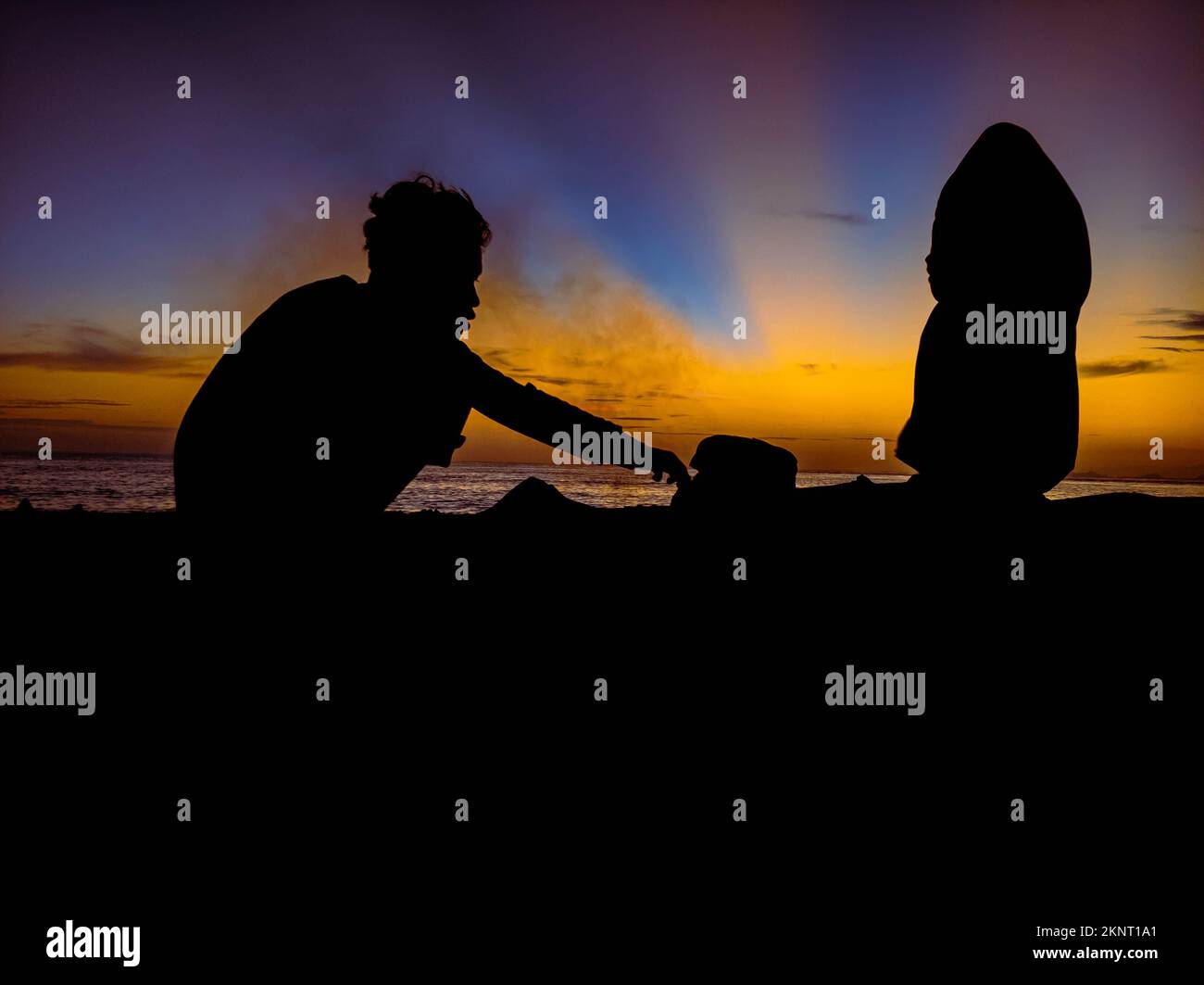 silhouette de personnes avec lever du soleil sur la plage Banque D'Images
