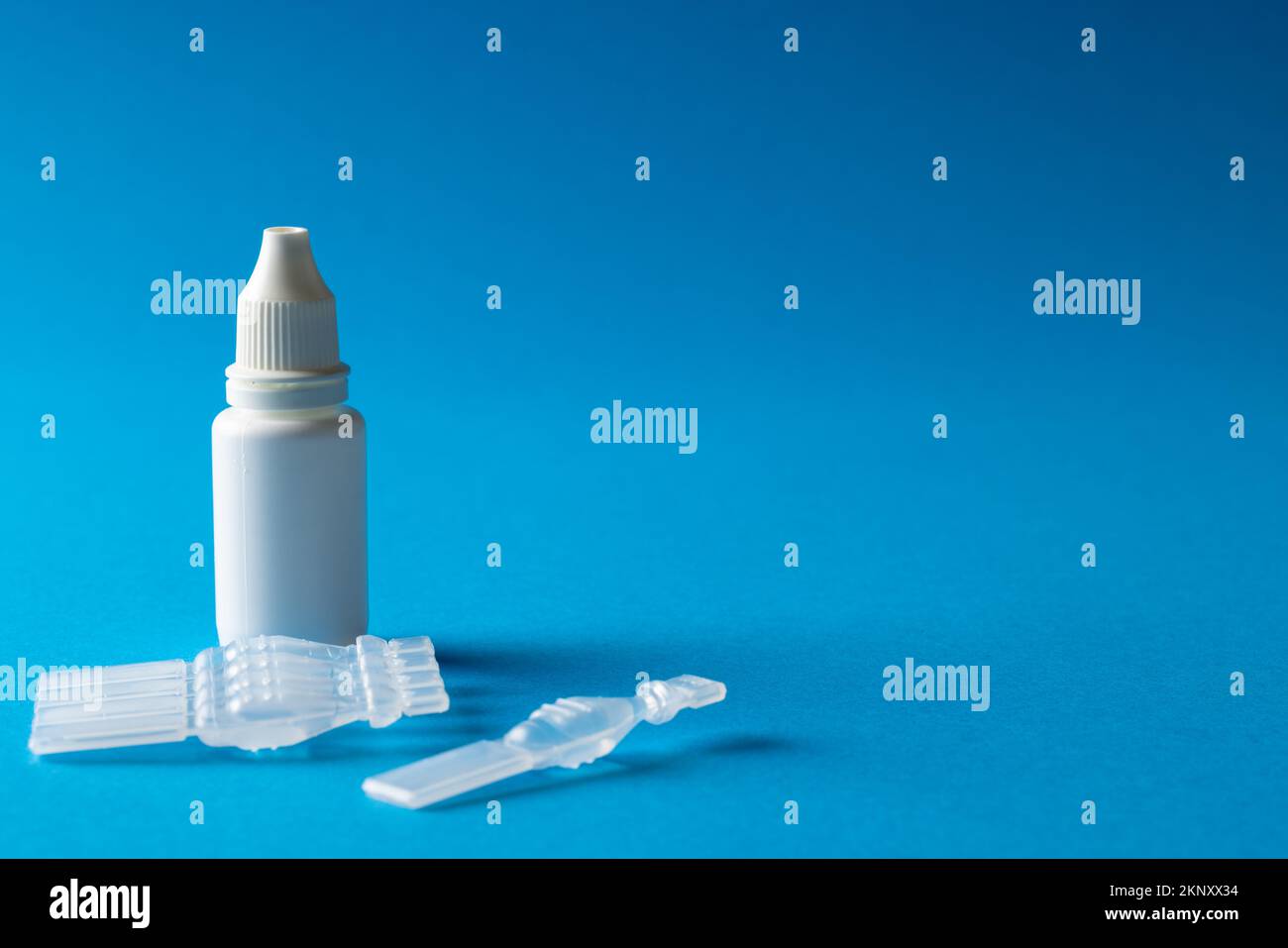 Composition des caplets de solution saline et du flacon compte-gouttes sur fond bleu avec espace de copie Banque D'Images