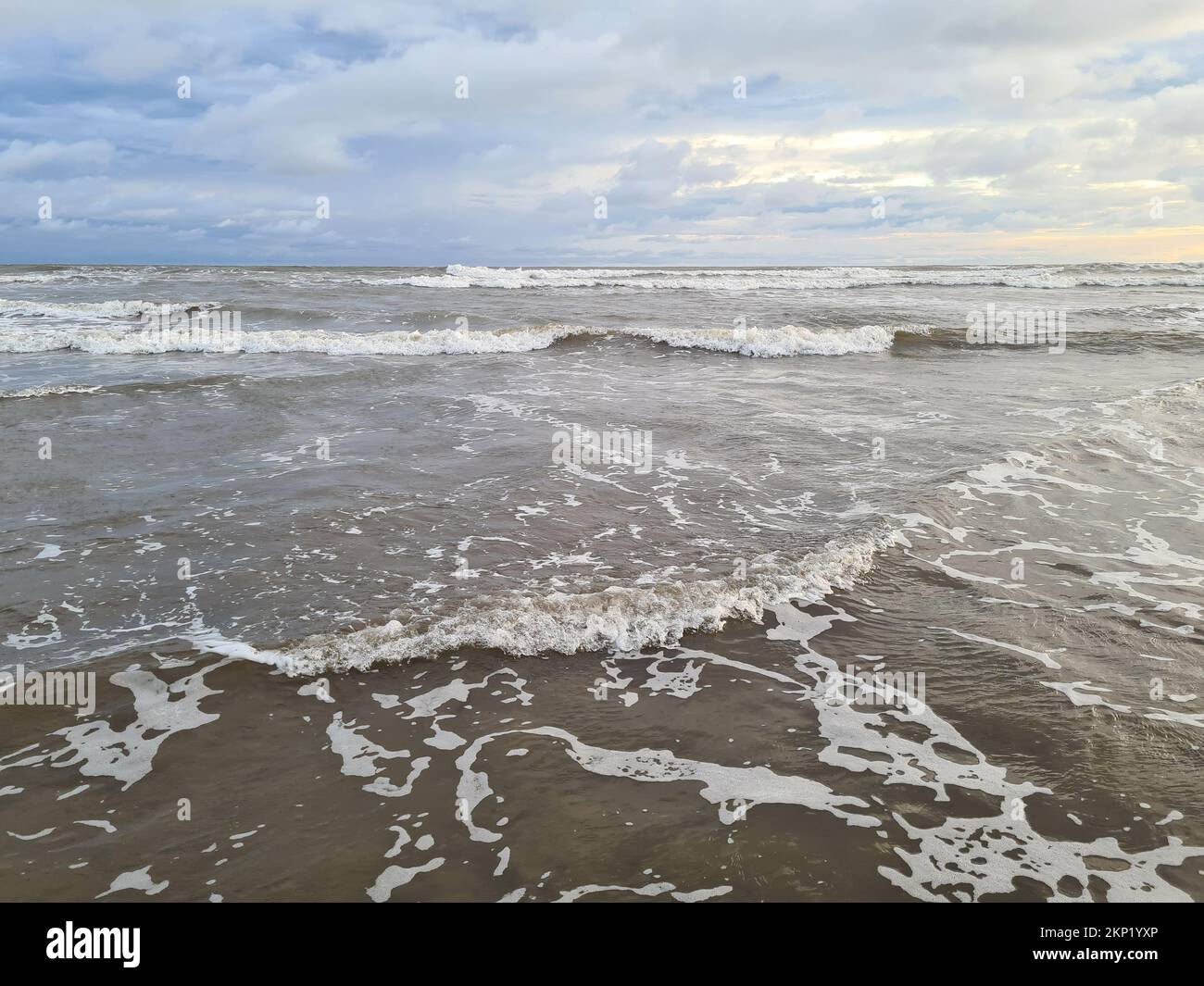 Plage de l'océan avec de petites vagues paysage sur temps nuageux Banque D'Images