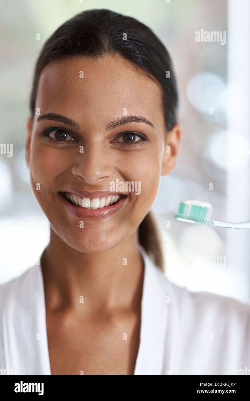 Pour un souffle frais et des dents brillantes. Portrait d'une femme souriante tenant une brosse à dents. Banque D'Images