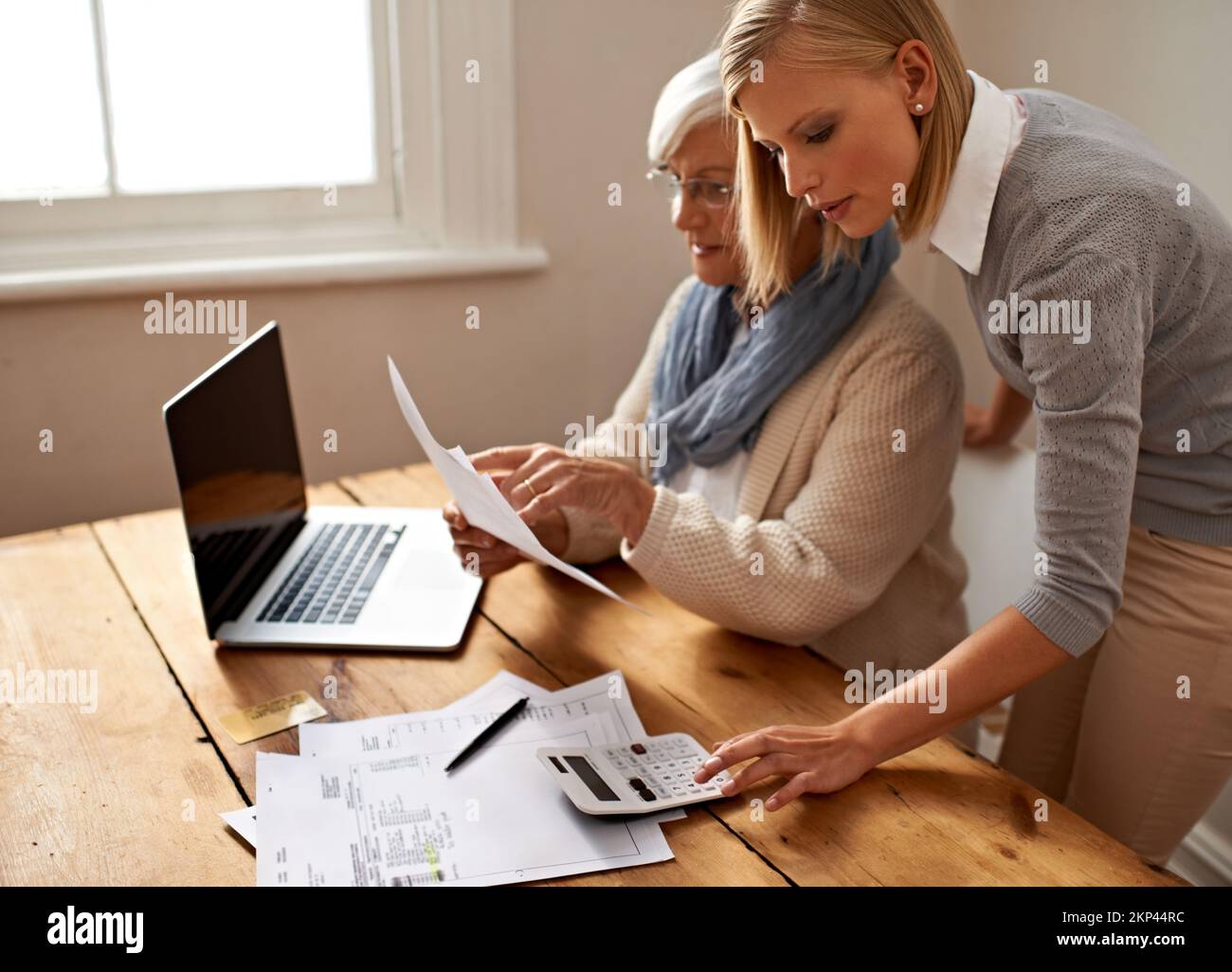 Ajoutons cela... vue courte d'une femme âgée qui reçoit de l'aide de sa petite-fille pour ses finances. Banque D'Images