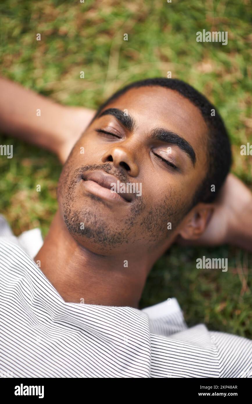 Faire une sieste à l'extérieur. un beau jeune homme couché sur l'herbe à l'extérieur. Banque D'Images