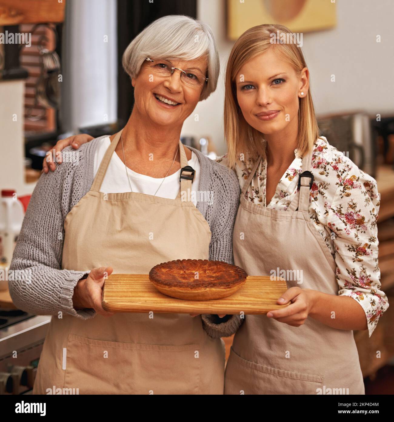 Le gâteau de la convivialité. une belle jeune femme et sa grand-mère montrant leurs compétences de boulangerie. Banque D'Images