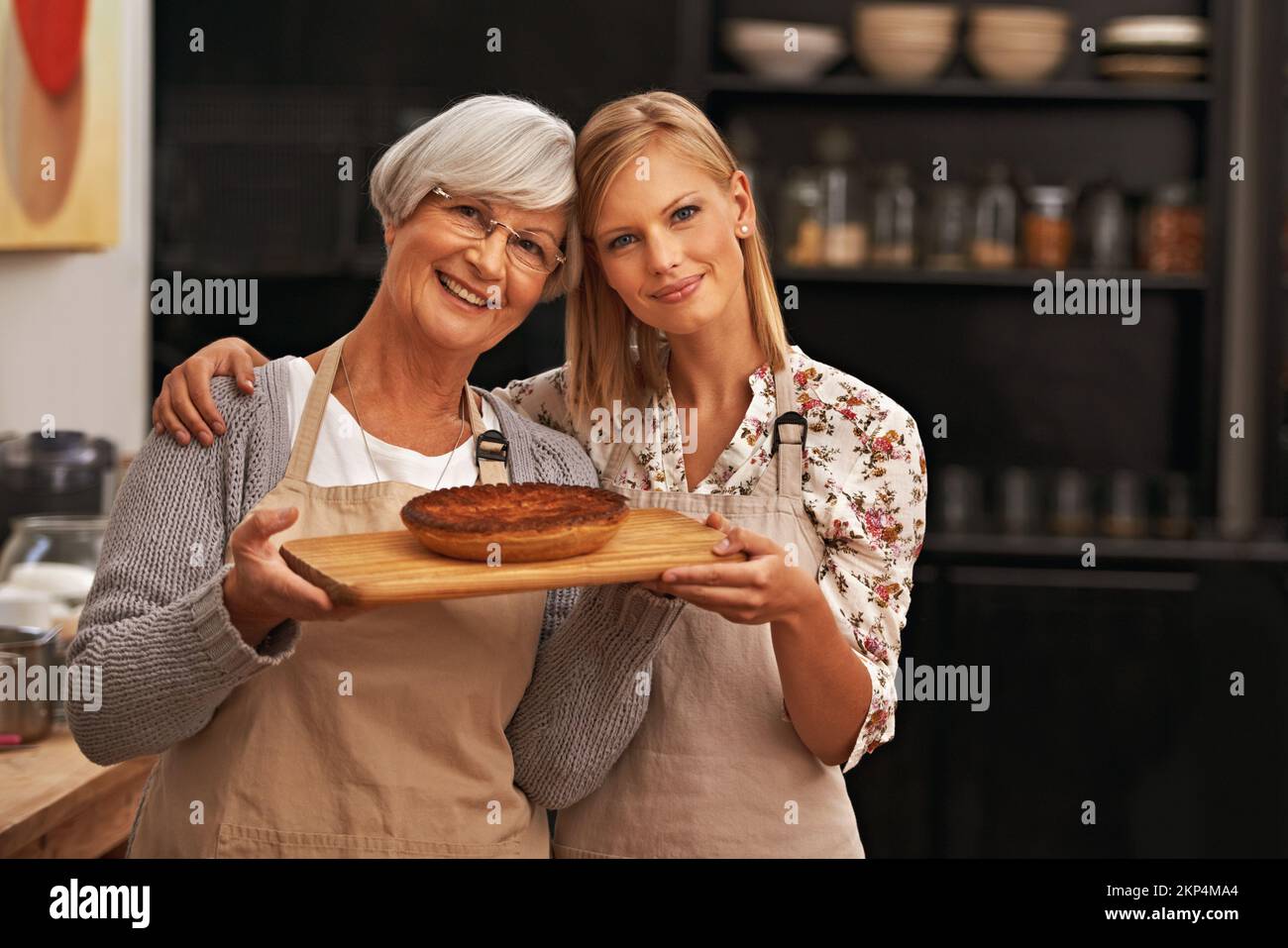 Collage de produits de boulangerie. une belle jeune femme et sa grand-mère montrant leurs compétences de boulangerie. Banque D'Images
