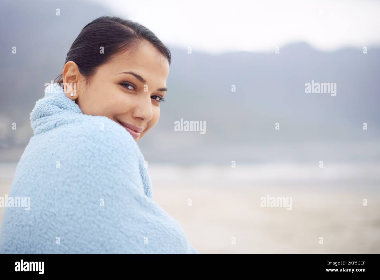 C'est un endroit calme sur la plage. une jeune femme attrayante assise sur la plage. Banque D'Images