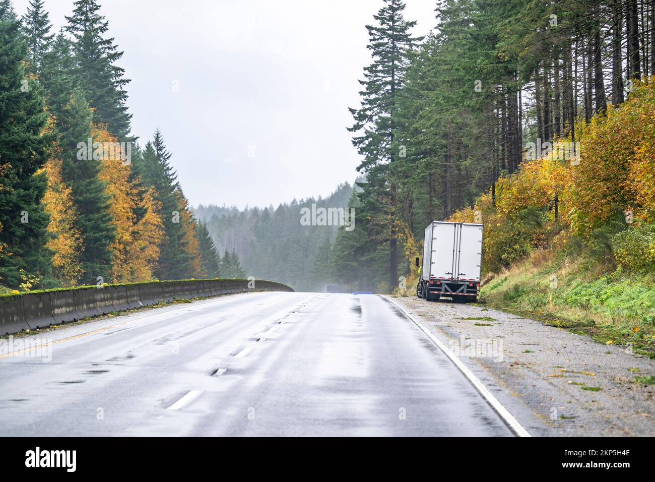 Camion semi-remorque de grande taille cassé avec capot ouvert et semi-remorque hors service sur la route d'hiver avec tempête de pluie attendant le camion de remorquage ou le diagn Banque D'Images