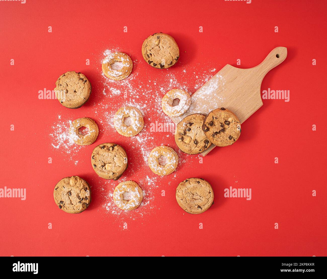 Concept créatif de la nourriture de Noël de biscuits maison doux, posé à plat sur fond rouge. Un délicieux plaisir pour toute la famille. Banque D'Images