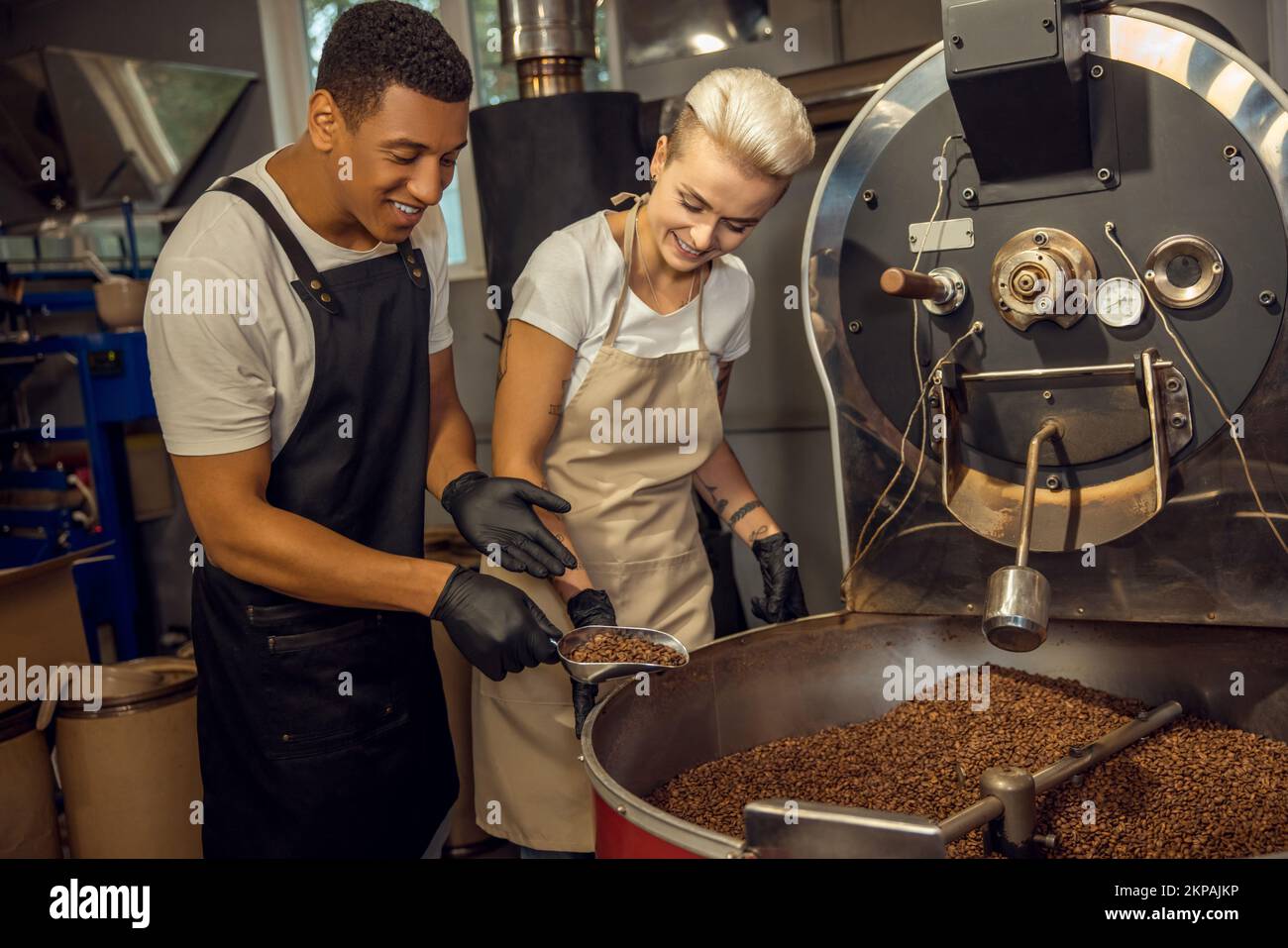 Des rôtissoires joyeux qui déterminent le niveau de torréfaction du café Banque D'Images