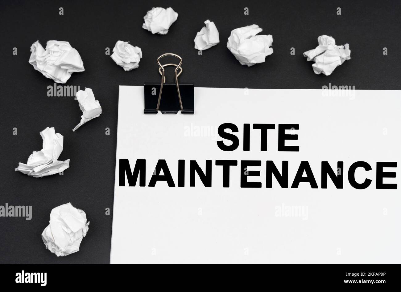 Concept industriel. Sur fond noir, il y a des morceaux de papier et de papier froissés avec l'inscription - entretien du site Banque D'Images