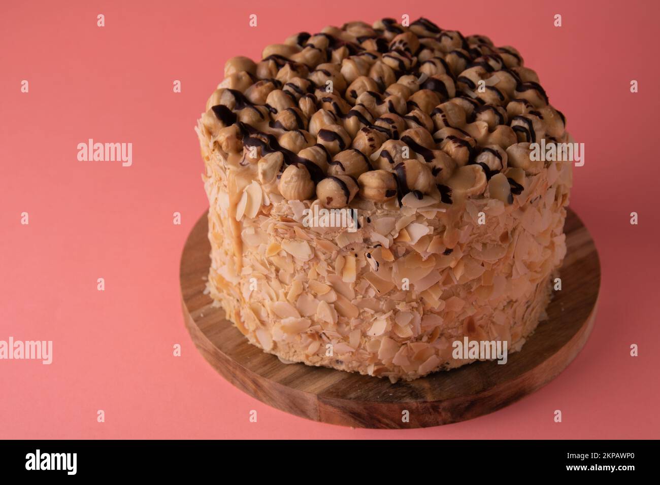 photo de gâteau rond de noyer sur une planche en bois vue latérale sur fond rose vue latérale Banque D'Images