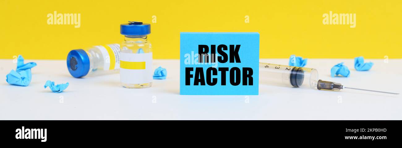 Médecine et concept de santé. Sur la table se trouve une seringue, des injections et un signe bleu avec l'inscription - FACTEUR DE RISQUE Banque D'Images