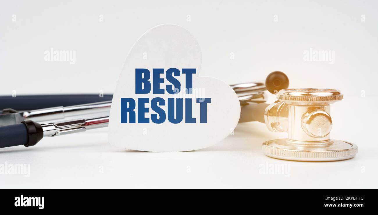 Concept médical. Il y a un stéthoscope sur la surface blanche, à côté il y a une plaque en forme de coeur avec l'inscription - MEILLEUR RÉSULTAT Banque D'Images