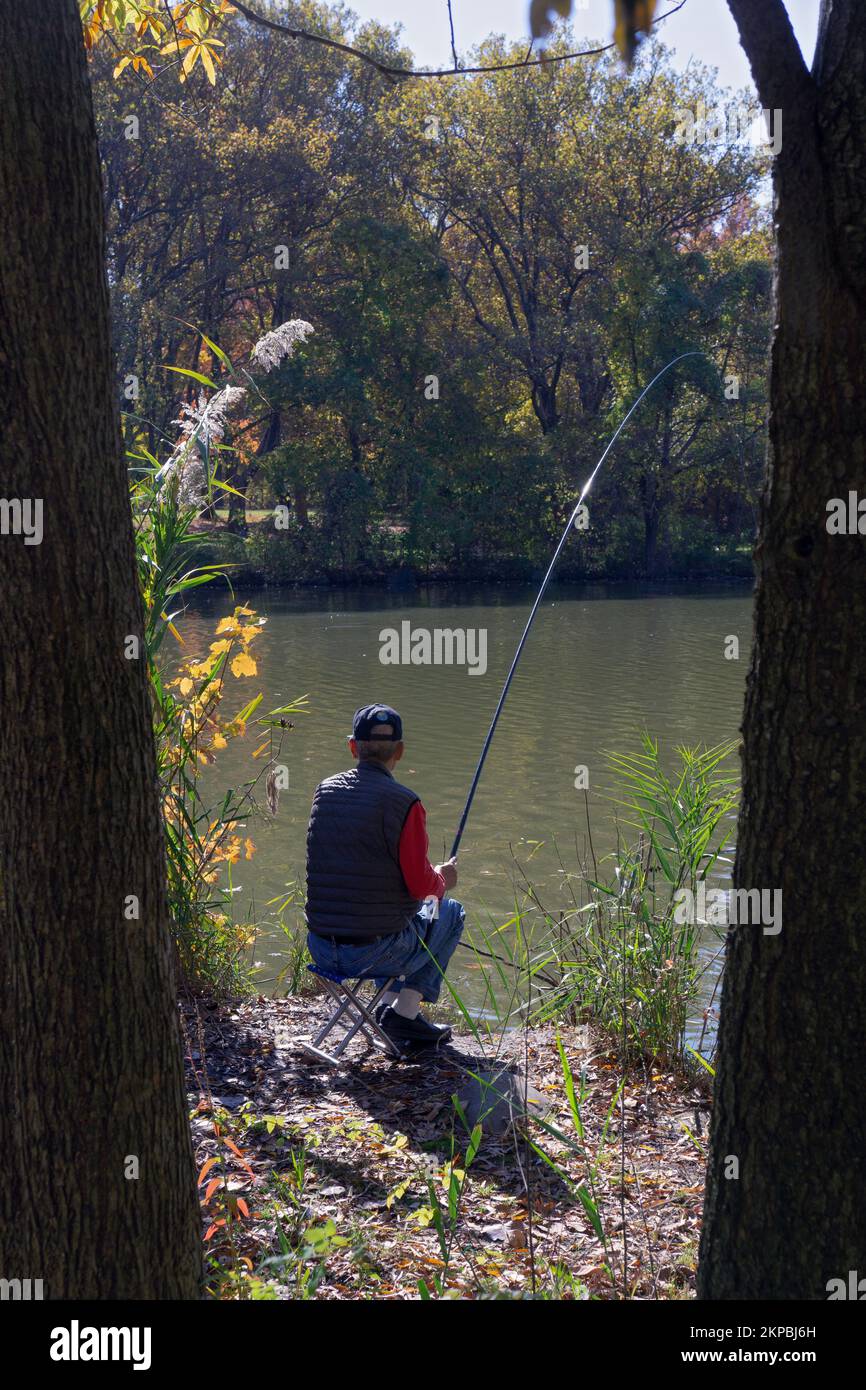 Un homme retraité pêchant dans un endroit tranquille près du lac à Kissena Park, Flushing, New York. Banque D'Images