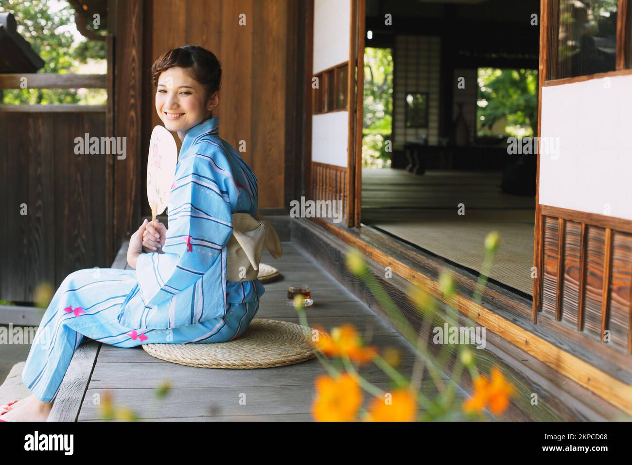 Femme japonaise dans un yukata se rafraîchi sur le porche Banque D'Images