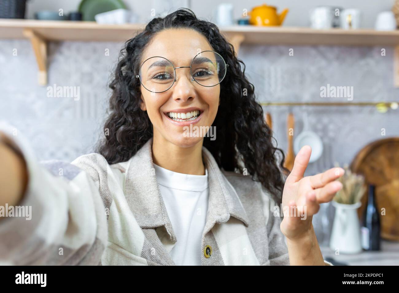 Gros plan. Jeune belle femme latino-américaine parlant sur appel vidéo à la maison, blogging, prenant selfie, souriant. Un clin d'œil à la caméra. Banque D'Images