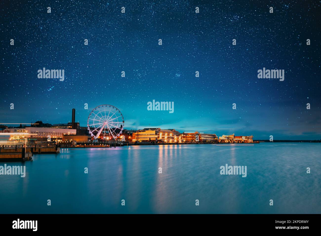 Helsinki, Finlande. Ciel étoilé bleu vif au-dessus de l'Embankment avec grande roue dans les illuminations nocturnes. Bleu clair ciel spectaculaire Banque D'Images