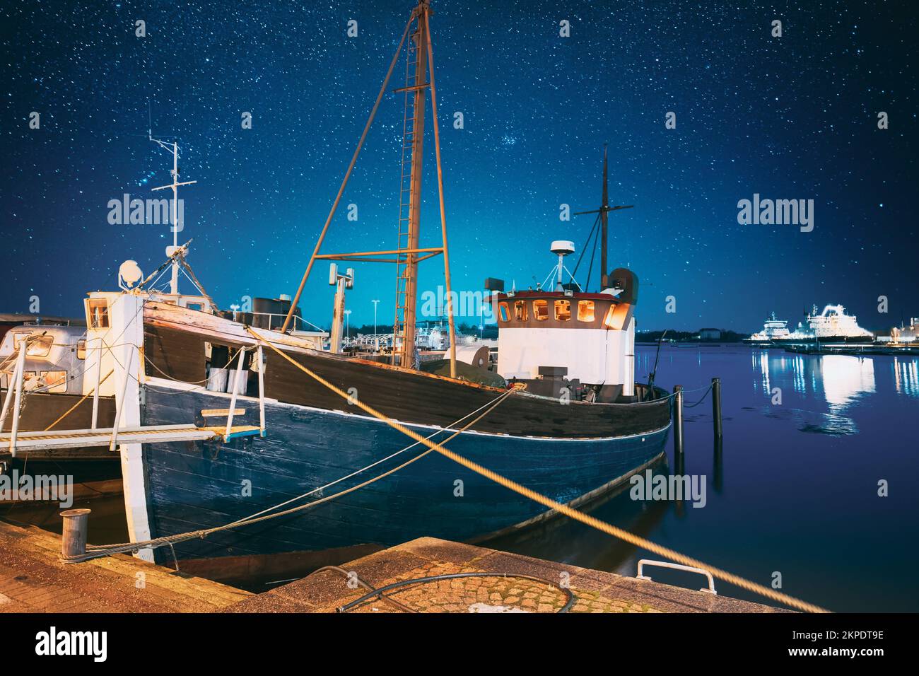 Helsinki, Finlande. Ciel étoilé bleu vif. Vue sur la pêche bateau de plaisance, bateau de moteur à l'embarcadère dans les illuminations nocturnes. Bleu clair ciel spectaculaire Banque D'Images