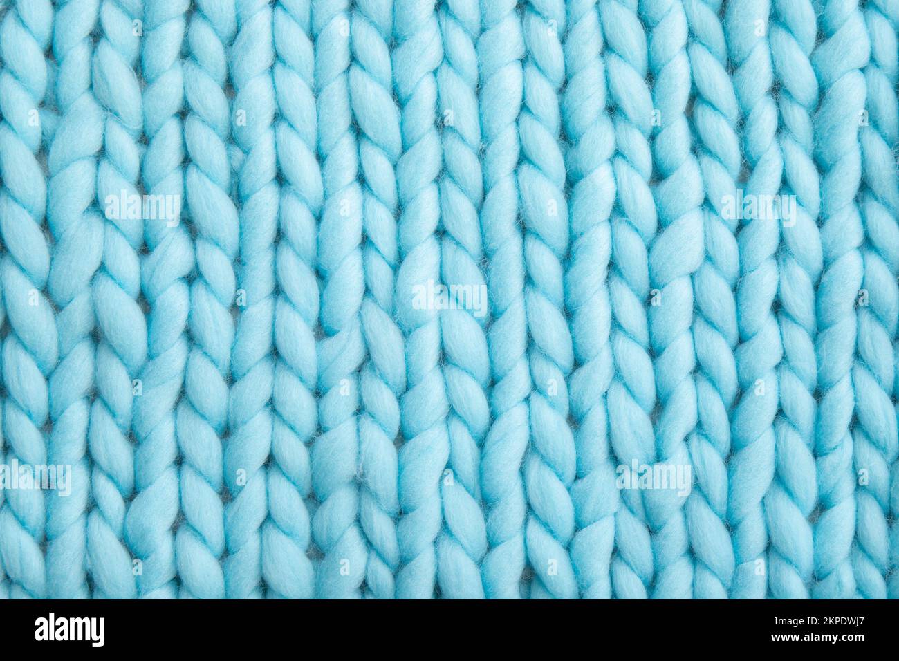 Gros plan au-dessus de l'arrière-plan en laine tricotée bleu clair. Banque D'Images