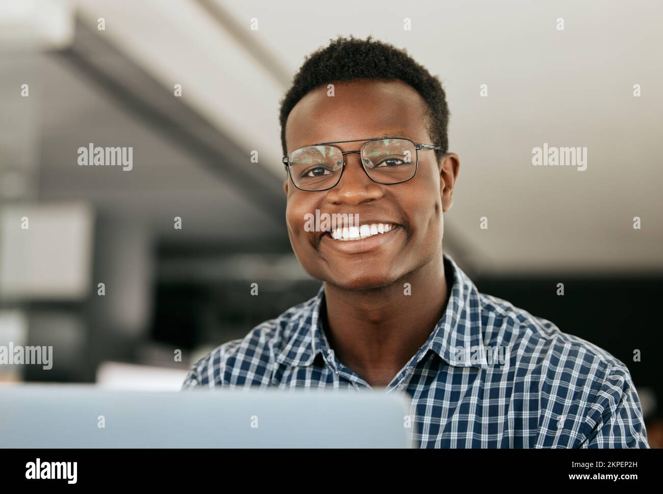 Portrait, ordinateur portable et support informatique avec un homme noir travaillant dans son bureau en tant qu'ingénieur ou technicien. Visage, heureux et sourire avec un nerd ou un geek au travail Banque D'Images