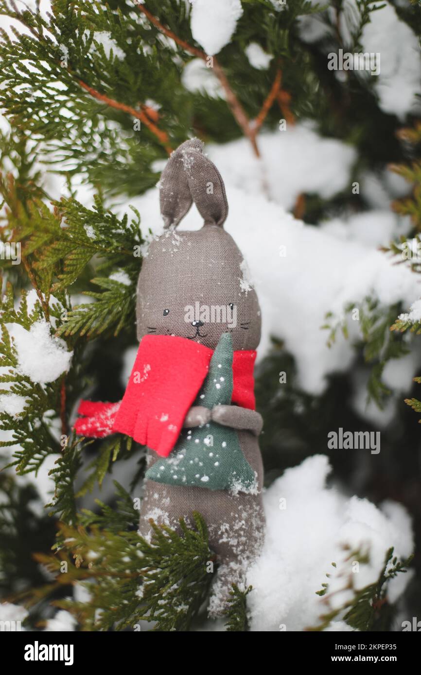 Joyeux Noël et Bonne Année. Lapin jouet suspendu sur une branche d'arbre de Noël, symbole de 2023 Banque D'Images