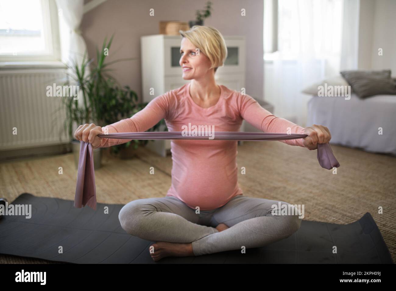 Femme enceinte faisant des exercices dans son appartement. Banque D'Images
