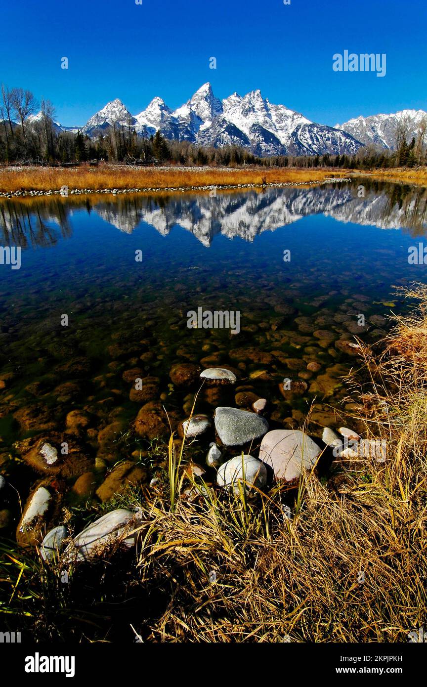 Chaîne de montagnes Tetons Tetons en hiver avec neige et arbres et reflet de la lumière dans la rivière Banque D'Images