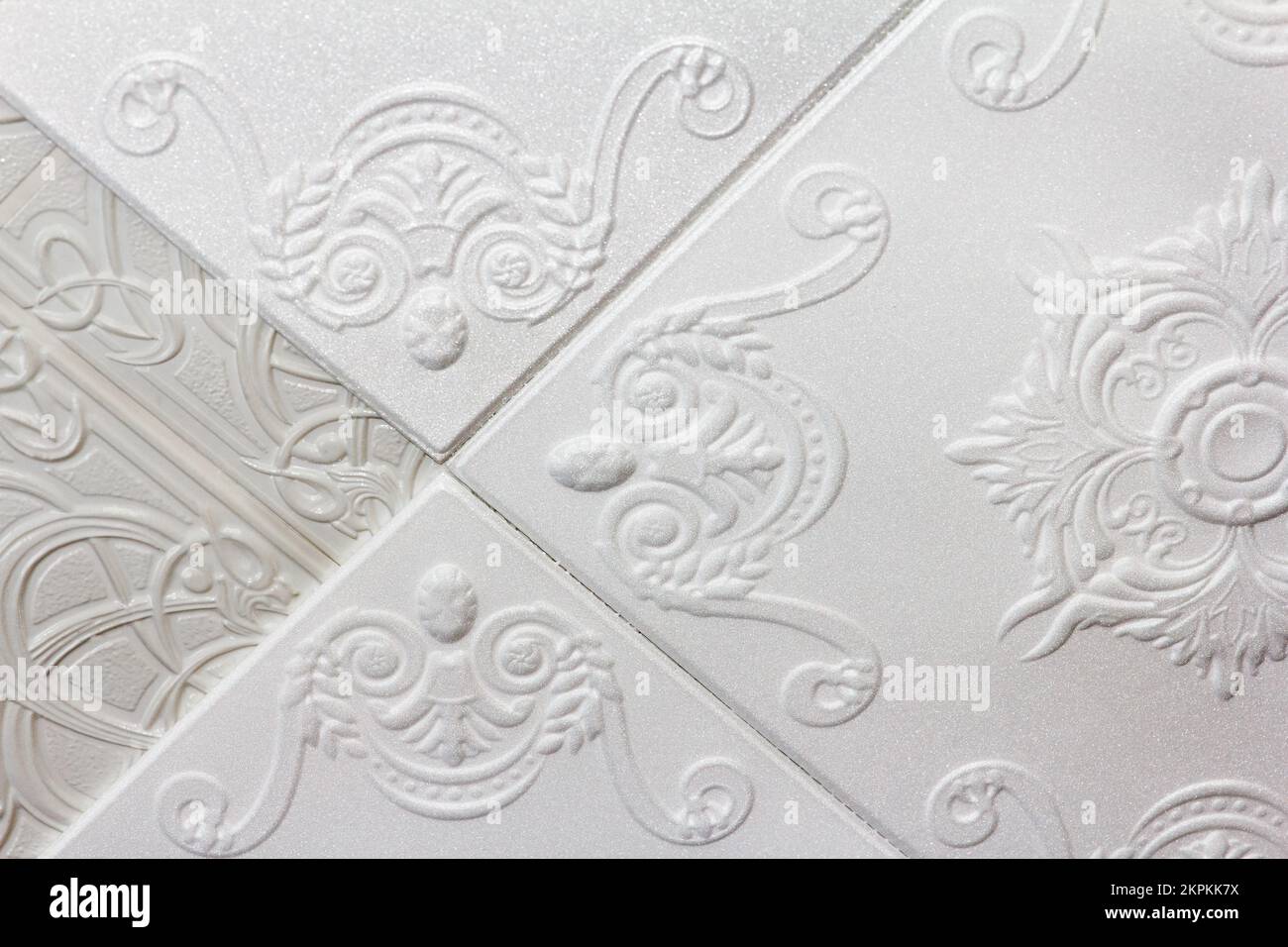 Réparation de plafond, facile. Nouvelles feuilles de mousse moulée avec beau motif, coller sur les anciennes plaques minces en plastique Banque D'Images