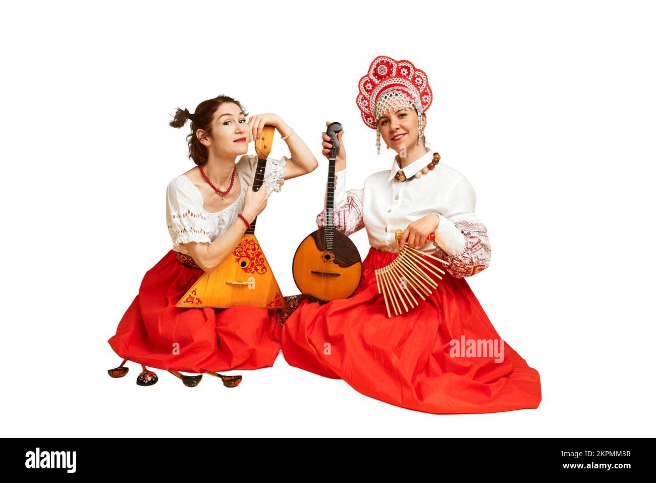 Femmes musiciens dans des robes folkloriques russes avec des instruments de musique, isolés sur fond blanc. Des artistes de Russie heureux dans des vêtements nationaux Banque D'Images