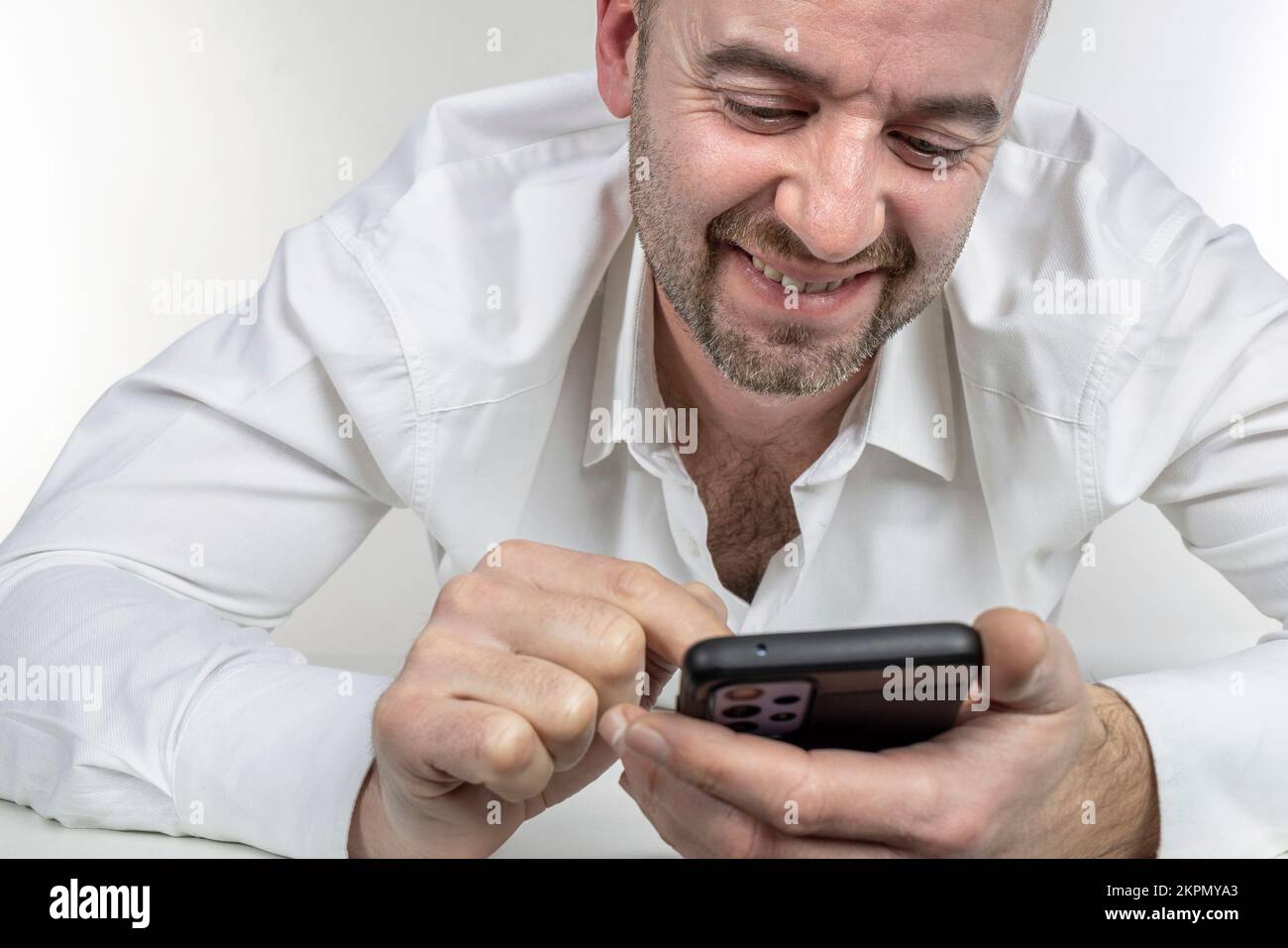 l'homme souriant utilise un smartphone Banque D'Images