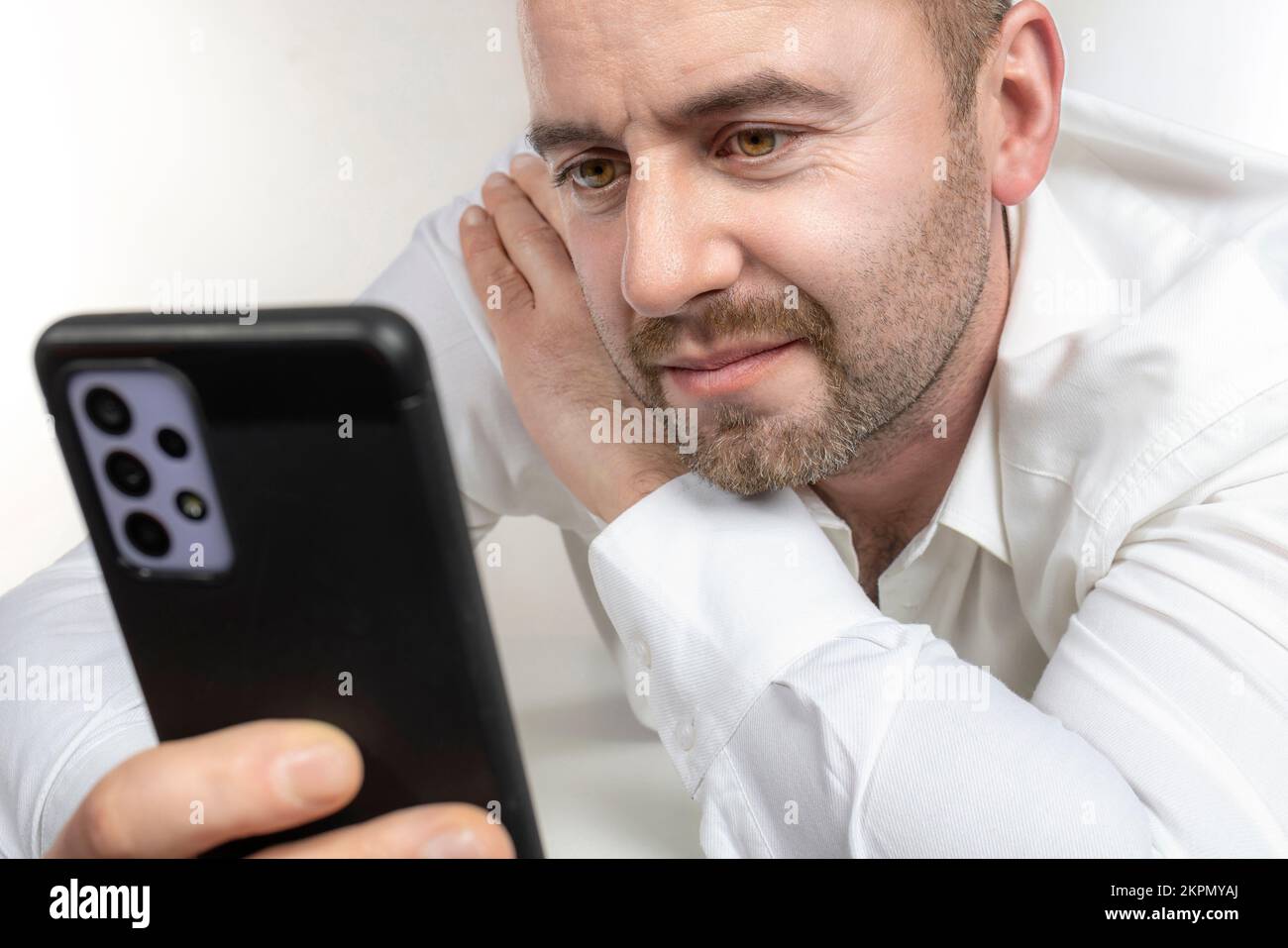 l'homme caucasien avec la barbe utilise un smartphone. prise de vue en studio Banque D'Images