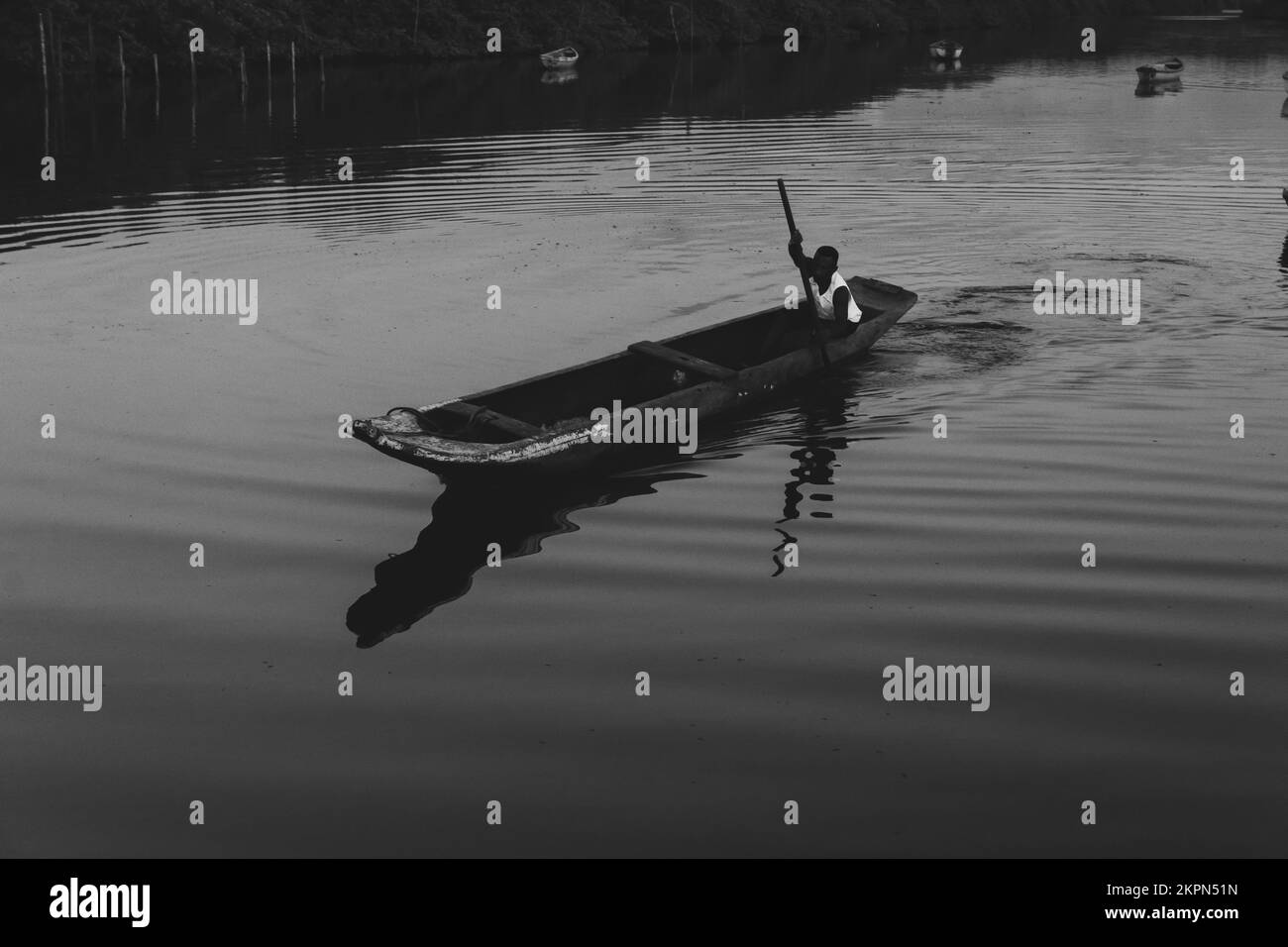 Aratuipe, Bahia, Brésil - 31 août 2018: Photographie en noir et blanc d'un pêcheur pagayant son canoë sur le fleuve Jaguaripe, ville d'Aratuipe, en t Banque D'Images
