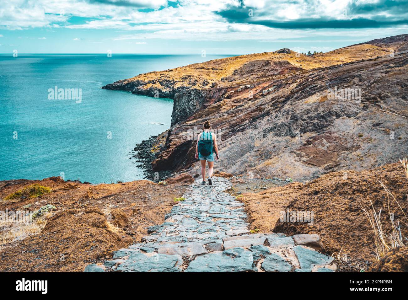 Description: Femme sportive marchant sur un sentier de randonnée pavé avec une vue pittoresque dans les magnifiques contreforts de l'île de Madère. São Lourenço, Madère est Banque D'Images