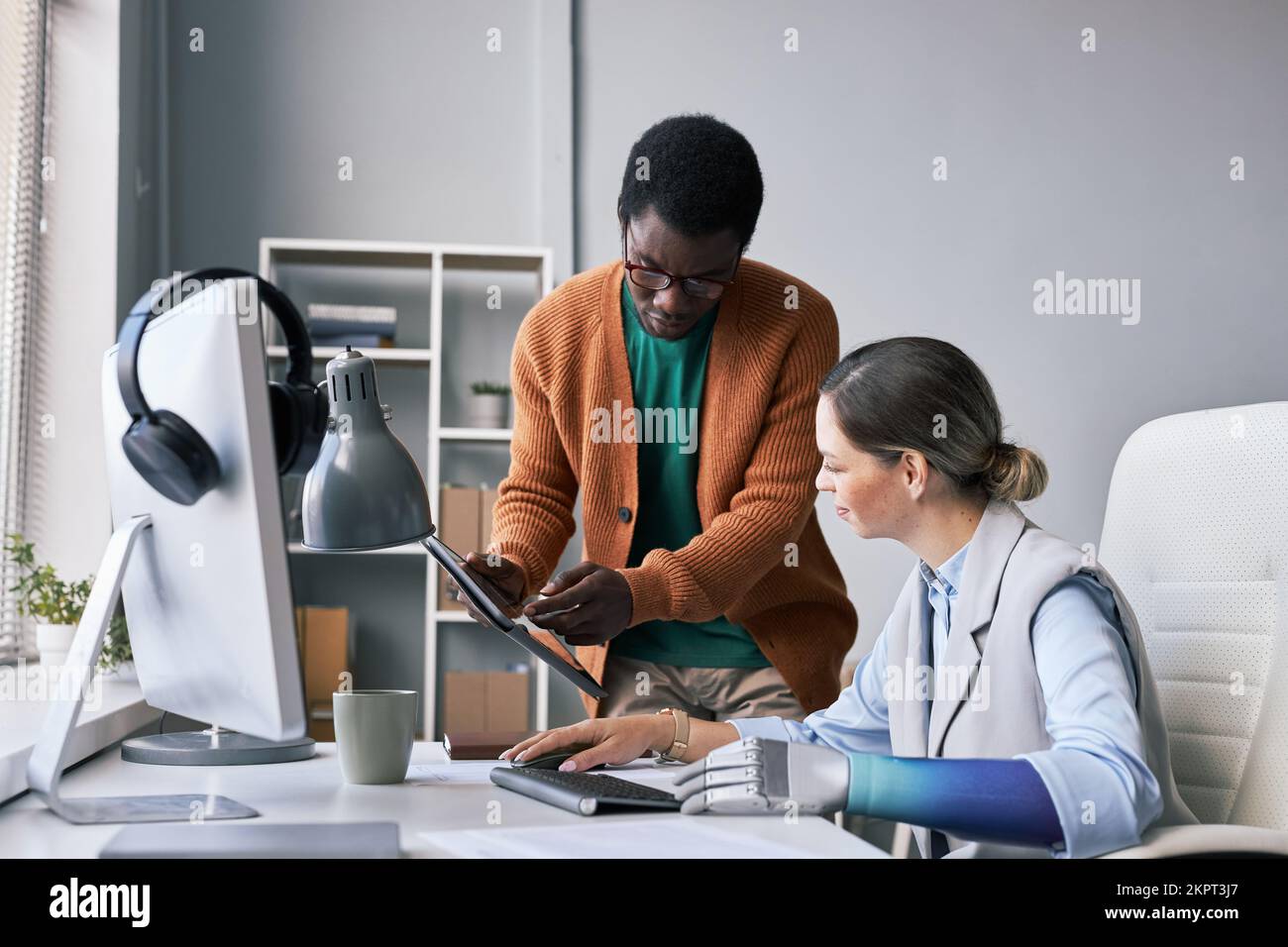 Chef de projet demandant à un collègue de l'aider à corriger un bogue logiciel Banque D'Images