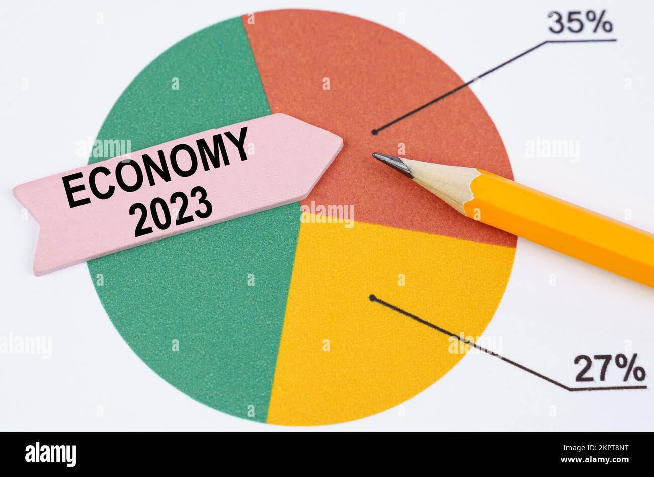 Concept d'entreprise. Sur le graphique à secteurs, il y a un crayon et une flèche avec l'inscription - Economy 2023 Banque D'Images