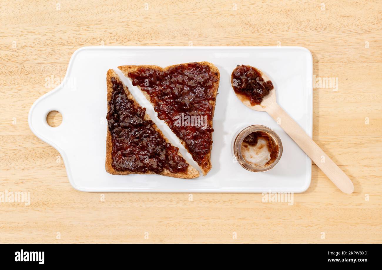 Plat de pain grillé sandwich avec confiture biologique de framboise sur table en bois Banque D'Images