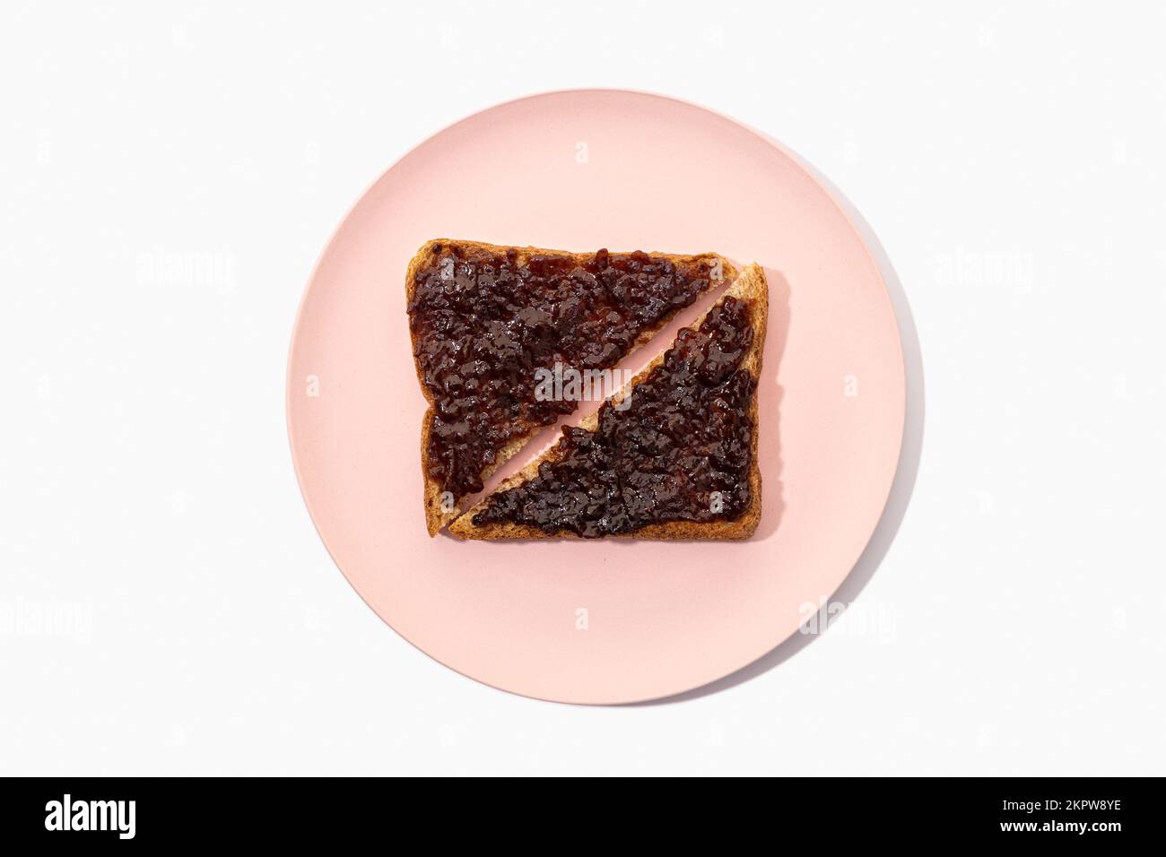 Toast de pain sandwich au blé entier et confiture biologique sur plaque isolée sur fond blanc. Pose à plat Banque D'Images