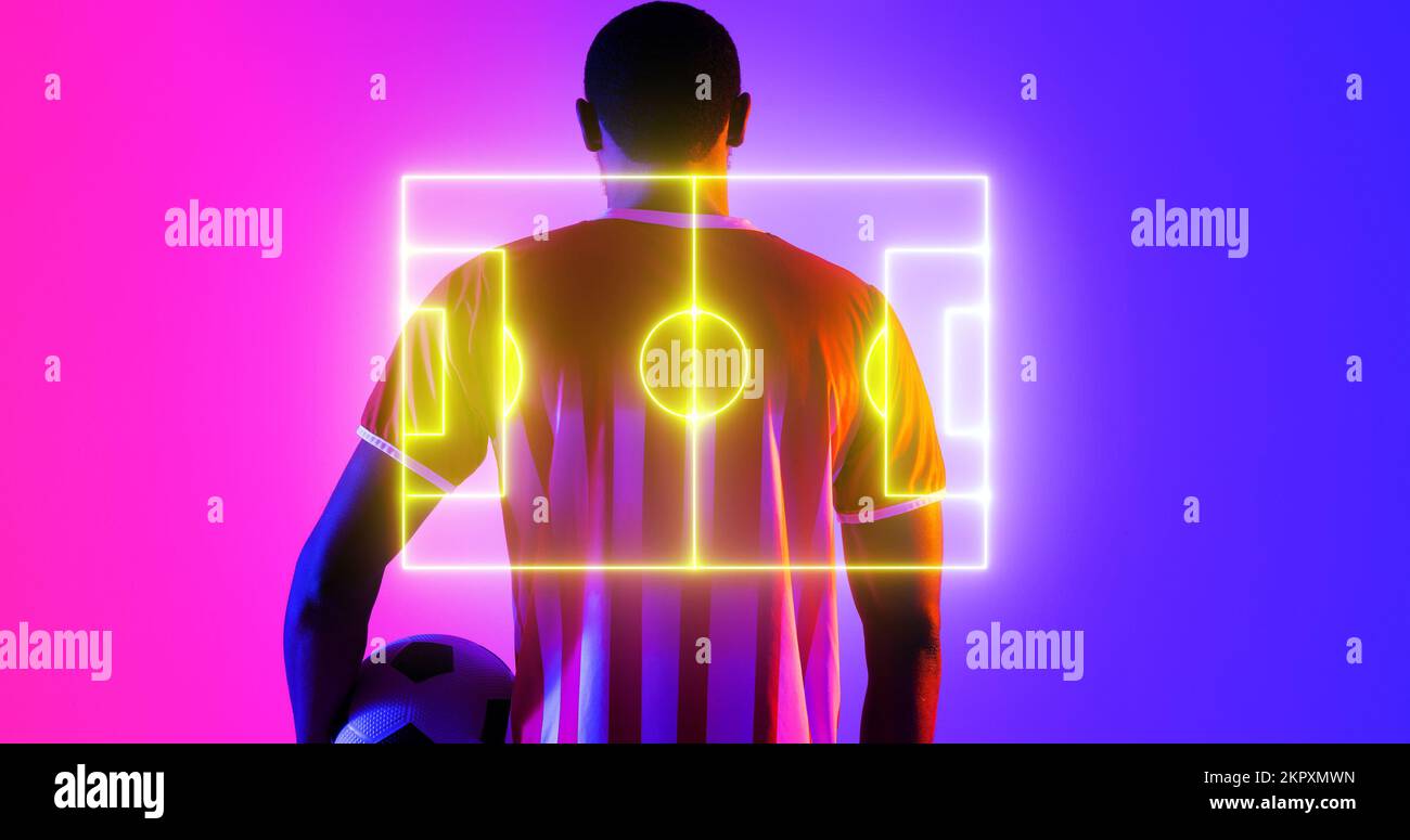 Vue arrière d'un homme afro-américain avec ballon et terrain de football éclairé sur fond de couleur Banque D'Images