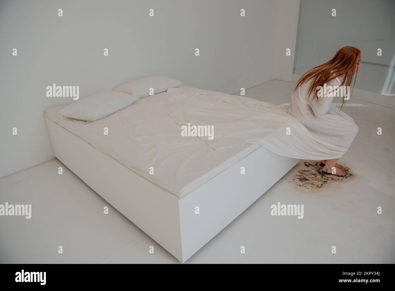 Femme dépressive assise sur un lit désordonné Banque D'Images