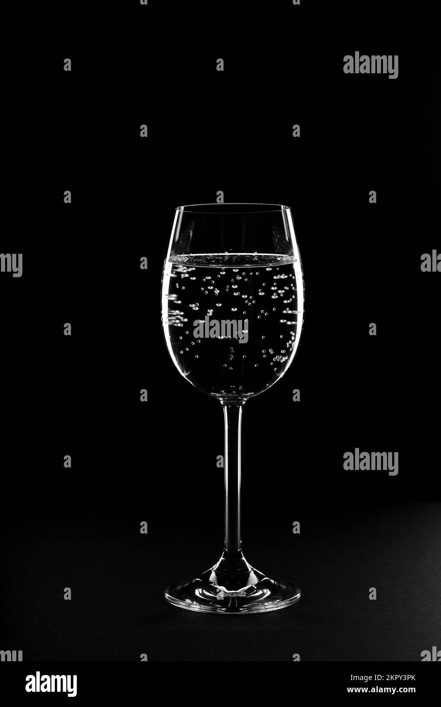 Verre d'eau de boisson avec gaz sur fond noir. Banque D'Images