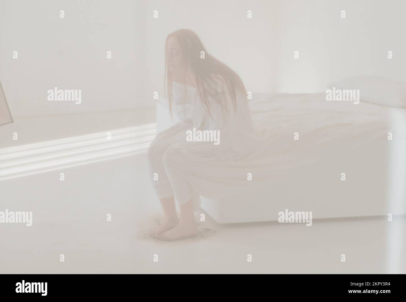 Femme dépressive assise sur un lit désordonné Banque D'Images