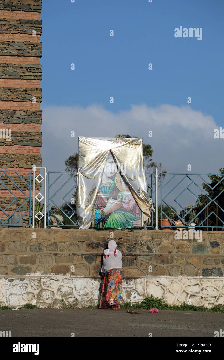 Femme priant à Marie à l'extérieur de la cathédrale d'Enda Mariam en Érythrée Banque D'Images