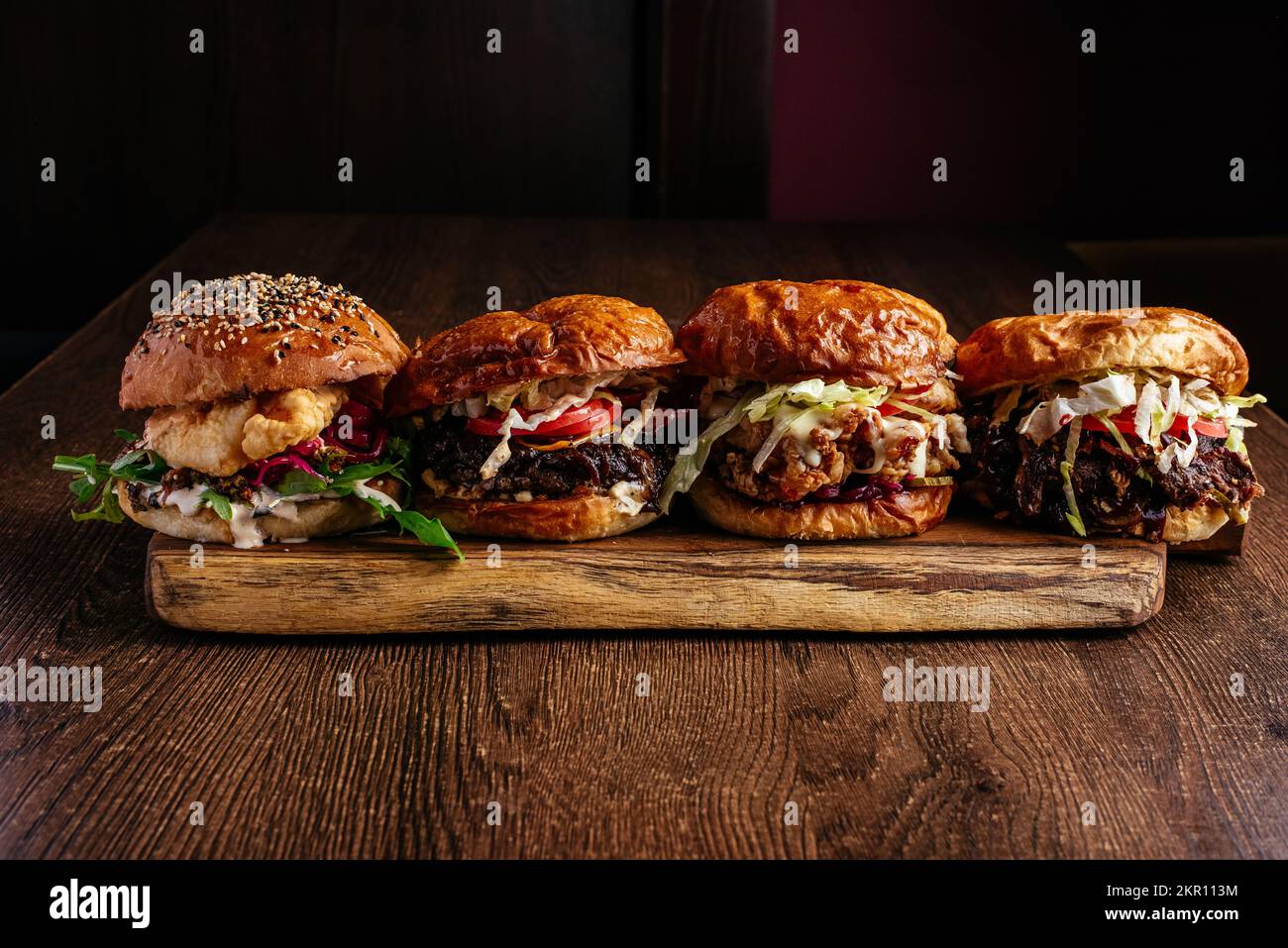 4 types de hamburgers sur une planche en bois Banque D'Images