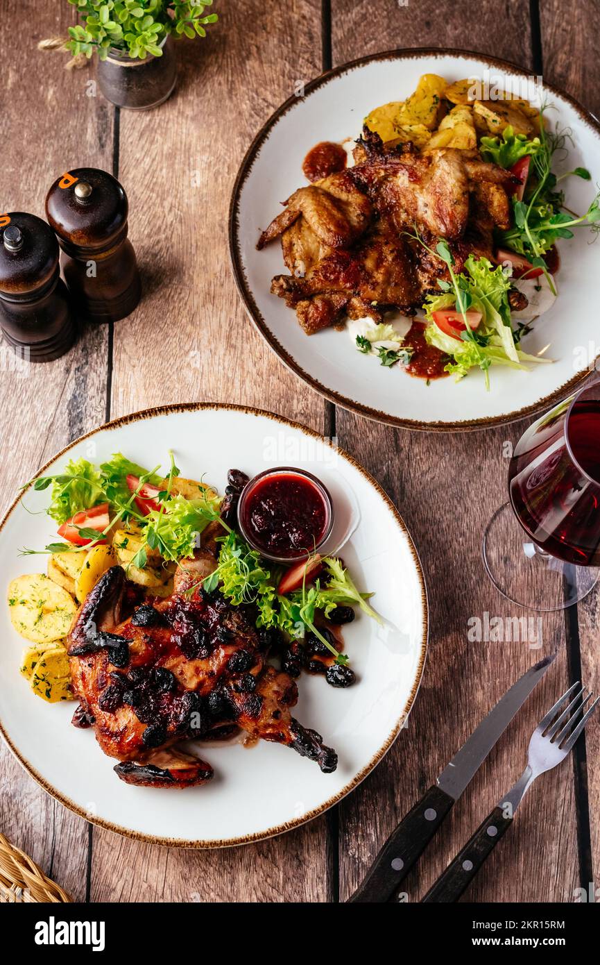 caille grillée avec sauce servie sur une assiette de légumes et h Banque D'Images