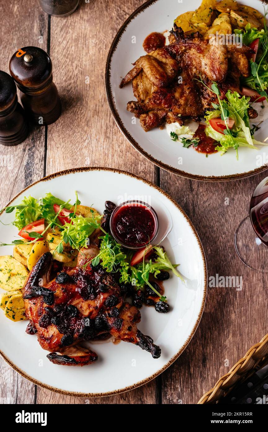 caille grillée avec sauce servie sur une assiette de légumes et h Banque D'Images