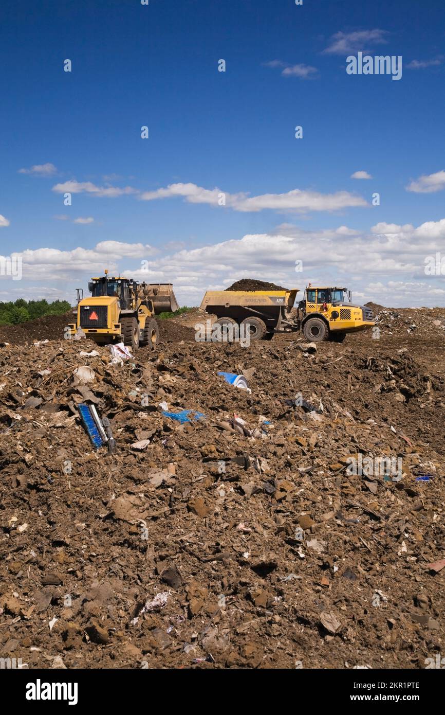 Chargeuse et camion-citerne Volvo A250 sur une masse de débris au site de gestion des déchets, Terrebonne, Québec, Canada. Banque D'Images