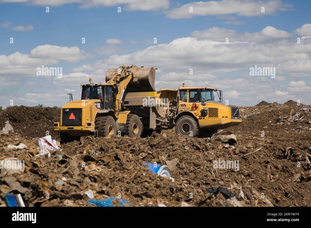 Chargeuse et camion-citerne Volvo A250 sur une masse de débris au site de gestion des déchets, Terrebonne, Québec, Canada. Banque D'Images